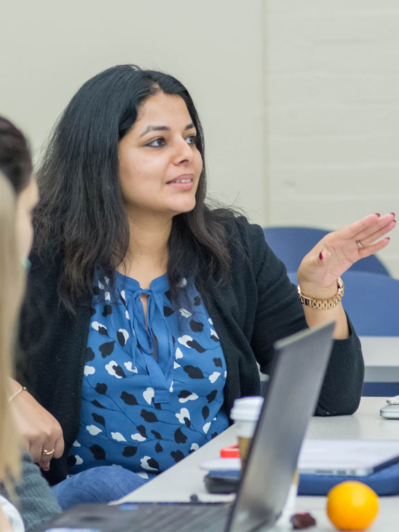 A woman having a discussion in a classroom.