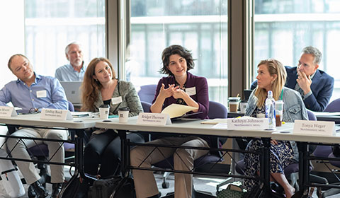 Students and faculty in a conference room.